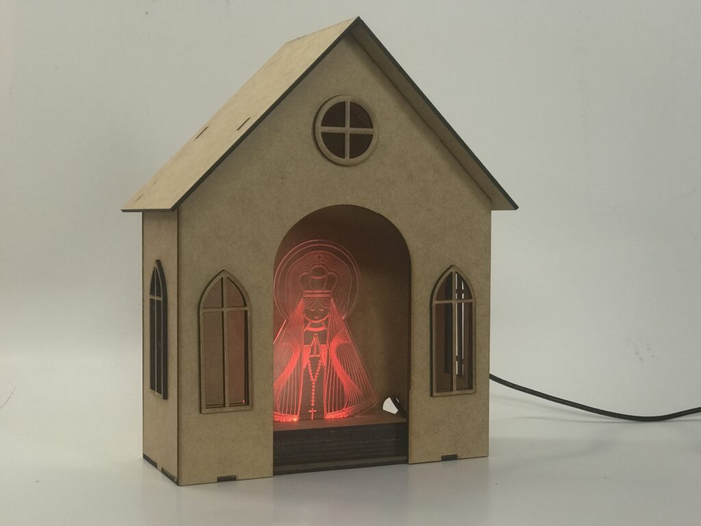 imagem de uma capela feita em mdf, com uma imagem feita em acrilico e uma base de mdf com led dentro, luminiaria